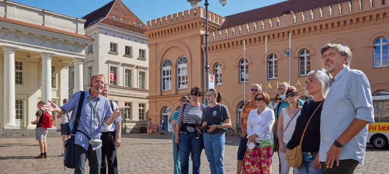 Stadtführer mit einer Gästegruppe auf dem Schweriner Markt vorm Rathaus. // © Oliver Borchert Stadtführer mit einer Gästegruppe auf dem Schweriner Markt vorm Rathaus. // © Oliver Borchert