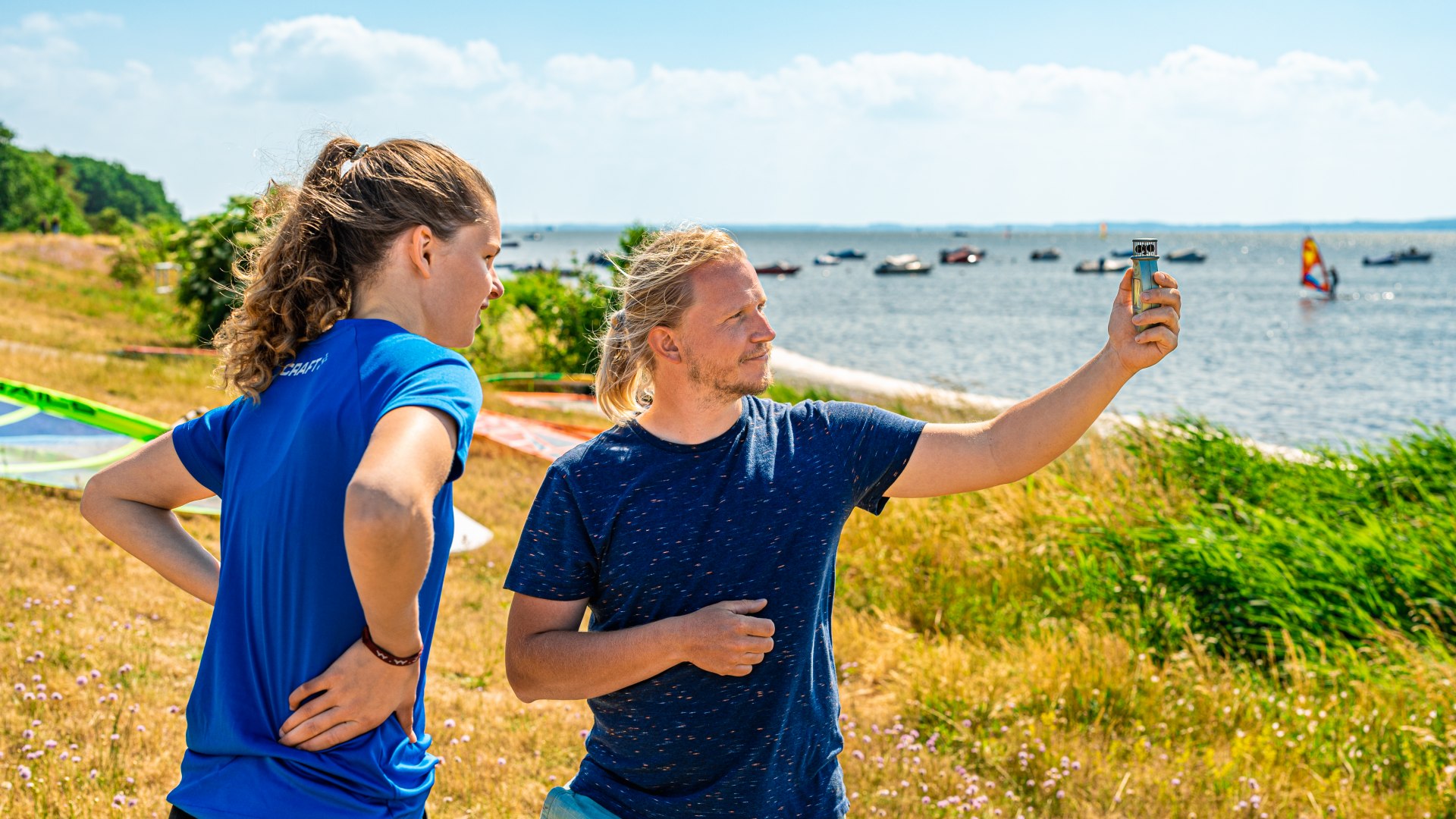 Als de wind te zwak is, zullen beginners moeite hebben om de vlieger in de lucht te houden. Een kitesurfinstructeur meet de wind met een windmeter.