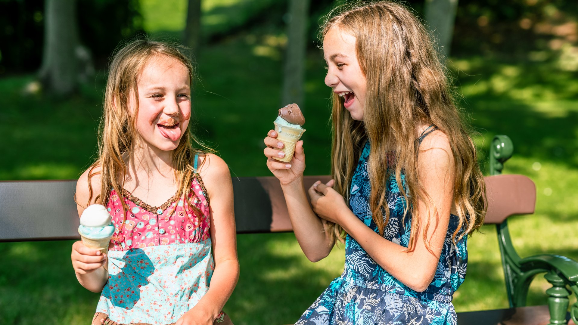 Twee kinderen eten ijs en lachen.