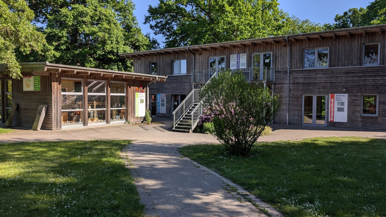Centrum twórcze stanowi serce naszego kempingu. W tym dwupiętrowym kompleksie budynków mieści się nasza pracownia produkcji świec, warsztat garncarski, sala do jogi, sala gier, siłownia oraz sauna. Przed budynkiem znajduje się niewielki plac z dużą ilością zieleni, na którym chętnie organizujemy różne uroczystości, a także zatrzymują się nasze mobilne sklepiki z produktami rolnymi, oferujące naszym gościom regionalne wyroby. // © Carla Pommerehne / Campingplatz Seehof GmbH Centrum twórcze stanowi serce naszego kempingu. W tym dwupiętrowym kompleksie budynków mieści się nasza pracownia produkcji świec, warsztat garncarski, sala do jogi, sala gier, siłownia oraz sauna. Przed budynkiem znajduje się niewielki plac z dużą ilością zieleni, na którym chętnie organizujemy różne uroczystości, a także zatrzymują się nasze mobilne sklepiki z produktami rolnymi, oferujące naszym gościom regionalne wyroby. // © Carla Pommerehne / Campingplatz Seehof GmbH
