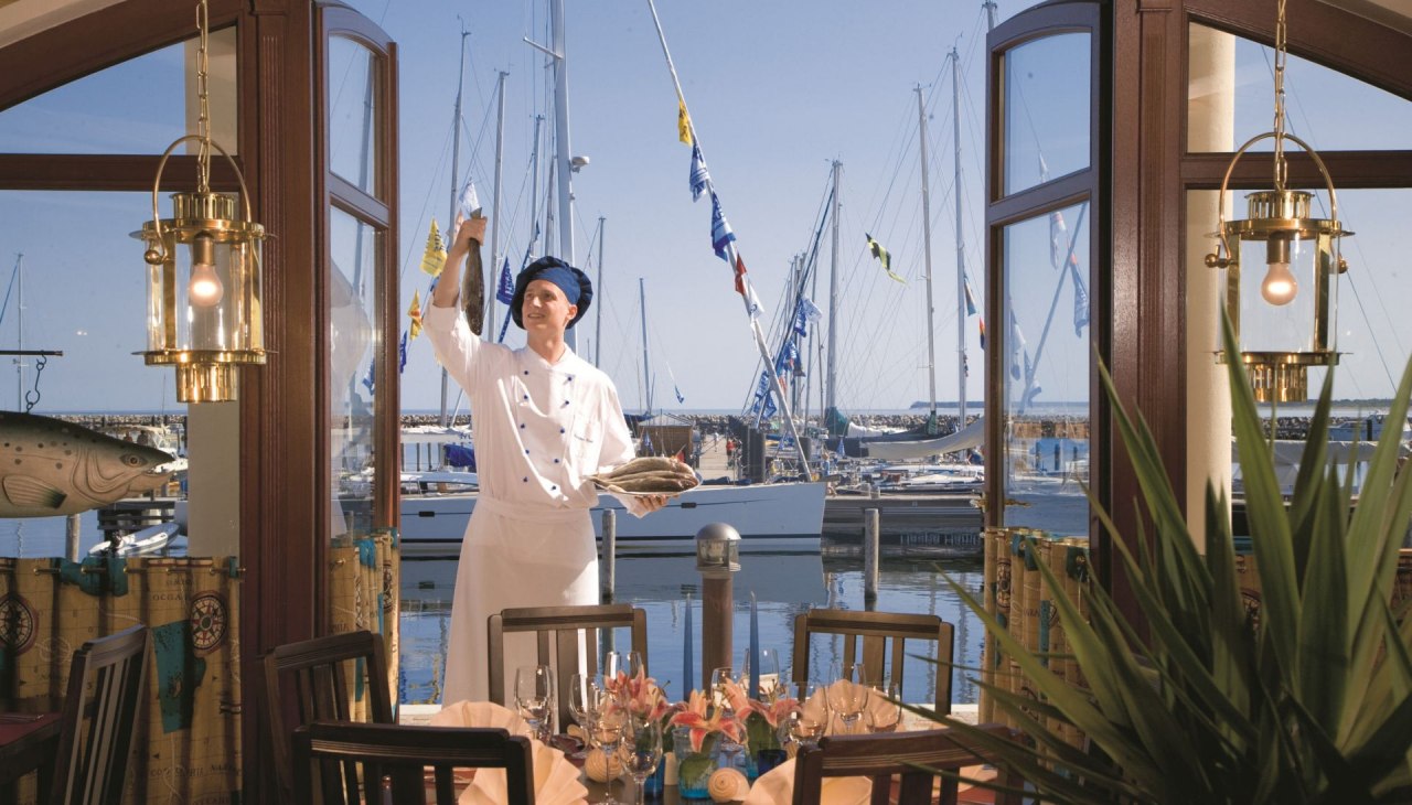 Goście mogą delektować się posiłkiem w stylowej atmosferze z widokiem na Morze Bałtyckie, w tym włoską pizzą i daniami ze świeżych ryb., © Yachthafenresidenz Hohe Düne, www.hohe-düne.de