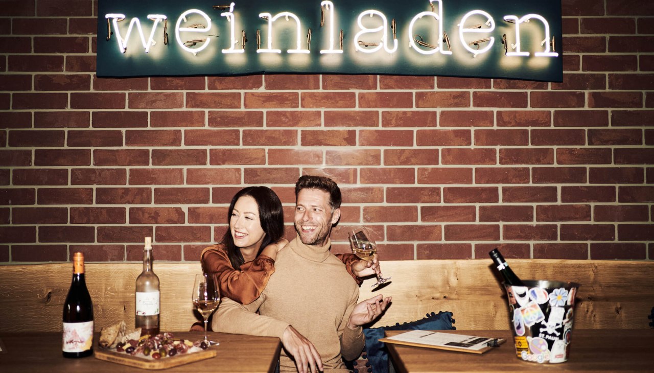 paar-lustig-auf-sitzecke-schriftzug-weinladen-binz, © Arne Lange