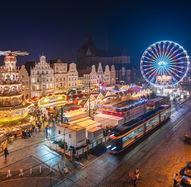 Glinsterende lichtjes en een feestelijke sfeer - de kerstmarkt van Rostock verwent bezoekers met historische gevels, geurige lekkernijen en een stralend reuzenrad in het centrum van de oude stad. // &copy; Erik Gross