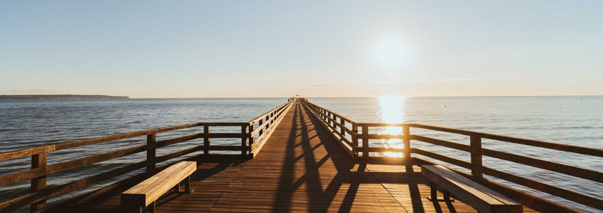 Sunrise over the Binz pier, with golden reflections on the Baltic Sea.