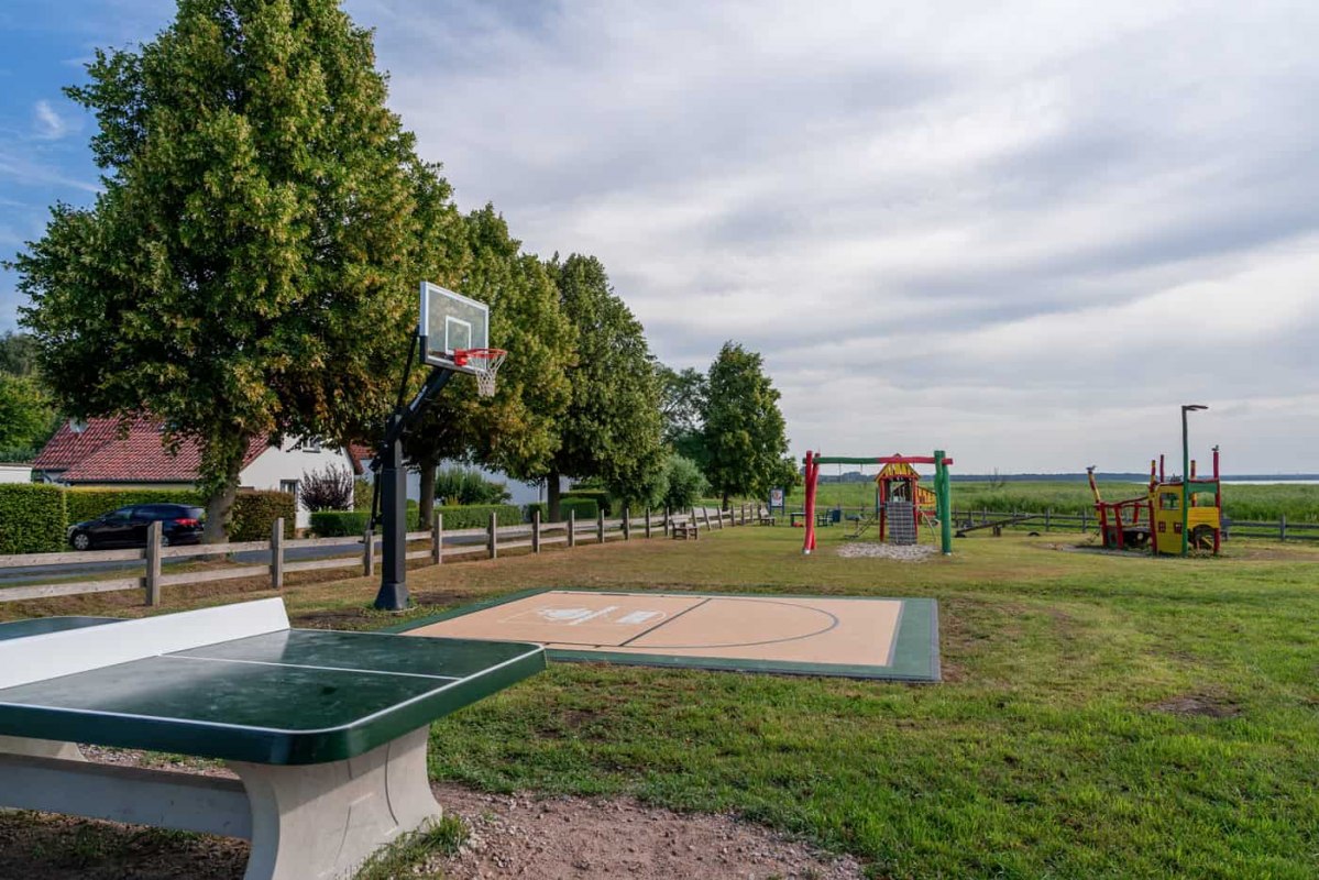A basketball court, a ping-pong table, and playground equipment at the playground on the Bodden in Niehagen, a neighborhood of Ahrenshoop. // © Maik Pixelino A basketball court, a ping-pong table, and playground equipment at the playground on the Bodden in Niehagen, a neighborhood of Ahrenshoop. // © Maik Pixelino