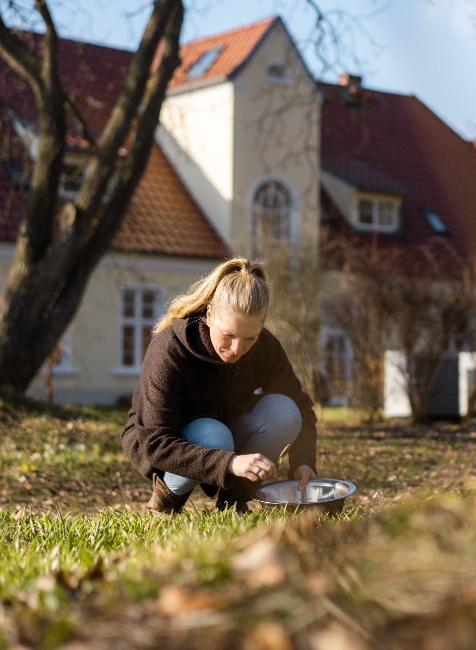 Levke is looking for herbs in the Ehmkendorf estate park for cooking together in the evening., © TMV/Gross