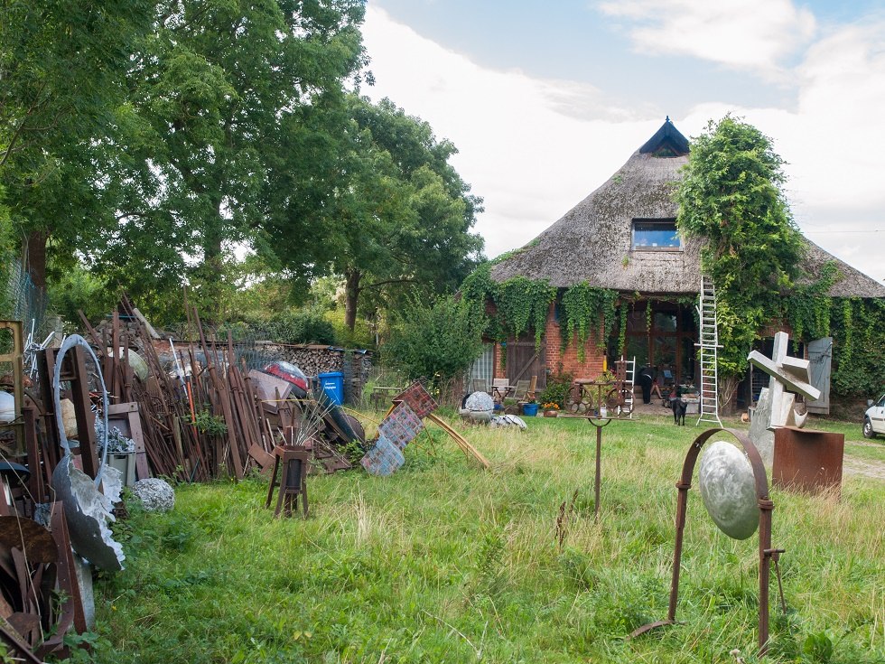 Cane roof house with artwork in the foreground // &copy; Frank Burger