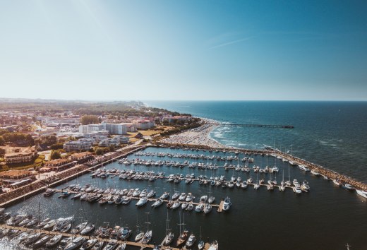 Luchtfoto van de jachthaven van K&uuml;hlungsborn met boten, strand en Baltische Zee in de zon.
