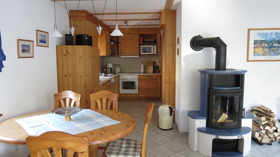 Living room with fireplace, TV and dining area, © F. Lembke