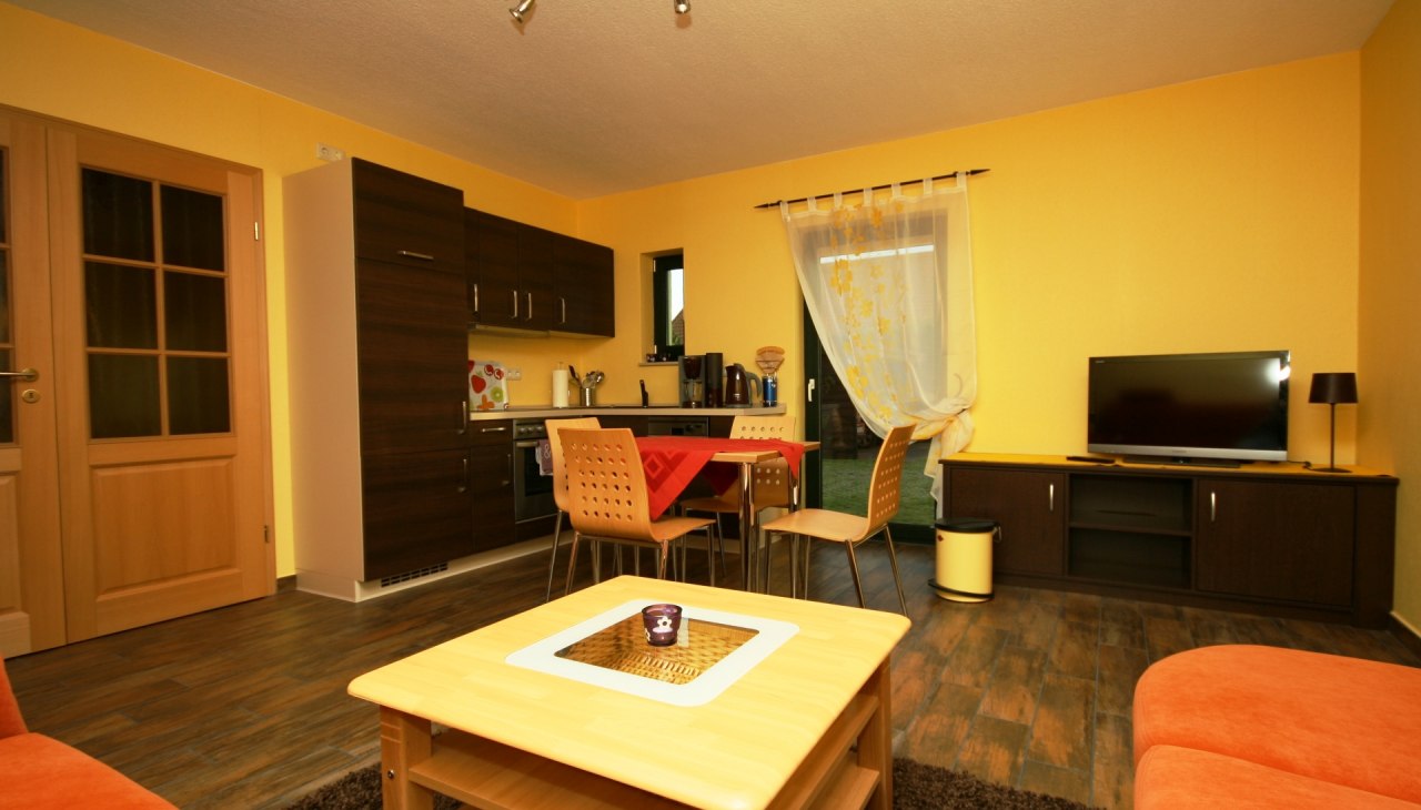 Volledig ingerichte eethoek met koelkast en vaatwasser en gemeubileerde woonkamer met slaapbank en tv., © Andreas Hollstein Volledig ingerichte eethoek met koelkast en vaatwasser en gemeubileerde woonkamer met slaapbank en tv., © Andreas Hollstein