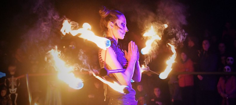 At the Lantern Festival at the Rostock Zoo, a woman wearing face paint is performing a fire show and holding a burning stick in her hand. // © Zoo Rostock/ Kloock At the Lantern Festival at the Rostock Zoo, a woman wearing face paint is performing a fire show and holding a burning stick in her hand. // © Zoo Rostock/ Kloock