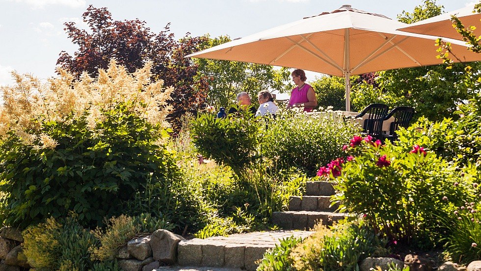 Guests having breakfast on the sunny terrace by the house // &copy; Gutshaus Barkow