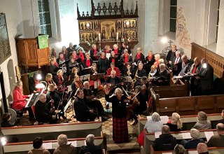 Christa Maier (center) with choir and orchestra in the village church of Pinnow, here a recording from last year. // &copy; F&ouml;rderverein Pinnower Orgel e.V.