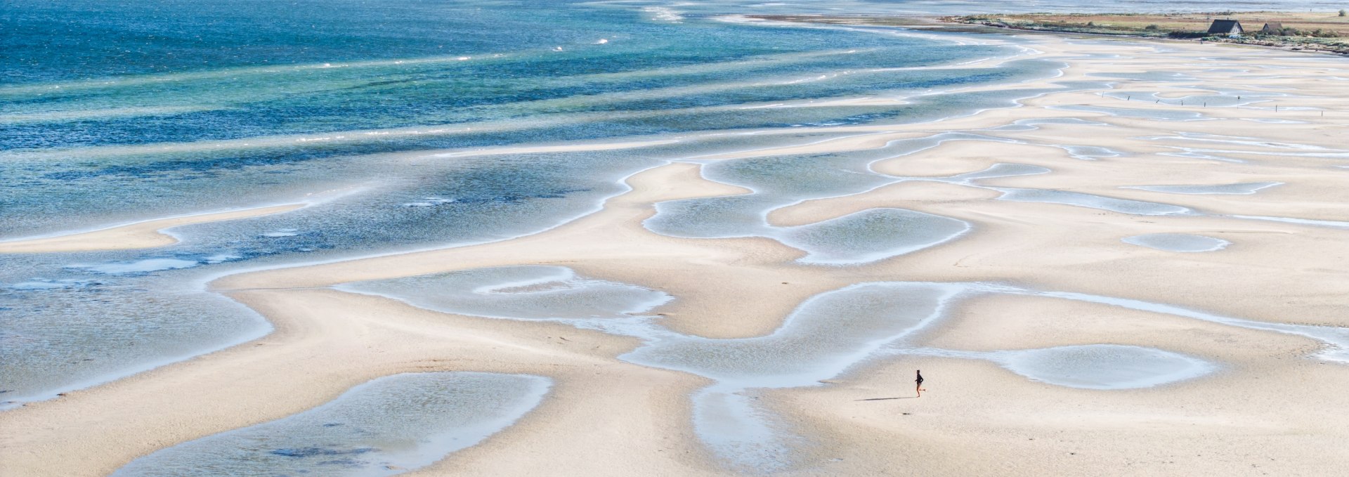 Extensive sandbanks and shallow water areas near Gollwitz on the island of Poel, taken at low tide under a clear sky.