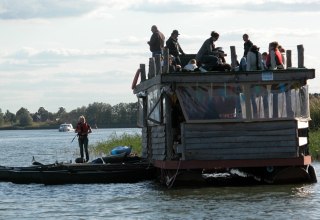 Unterwegs mit dem Floß - konzentriert am Steuer oder entspannt auf dem Oberdeck // © TOKON Unterwegs mit dem Floß - konzentriert am Steuer oder entspannt auf dem Oberdeck // © TOKON