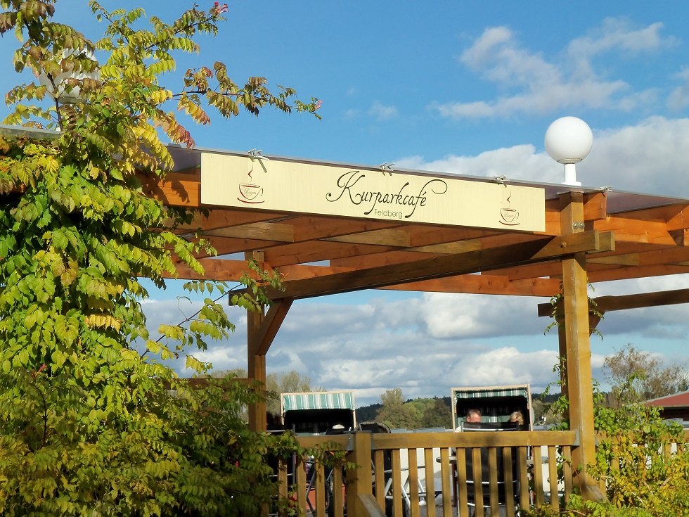 Zicht vanaf de straat op het logo van het caf&eacute; met strandstoelen op de achtergrond, &copy; Tortenmarie Photo
