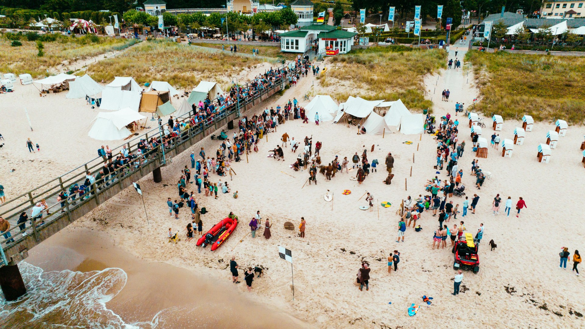 Vikingfestival met kamp op het strand van Göhren naast de pier vanuit de lucht.