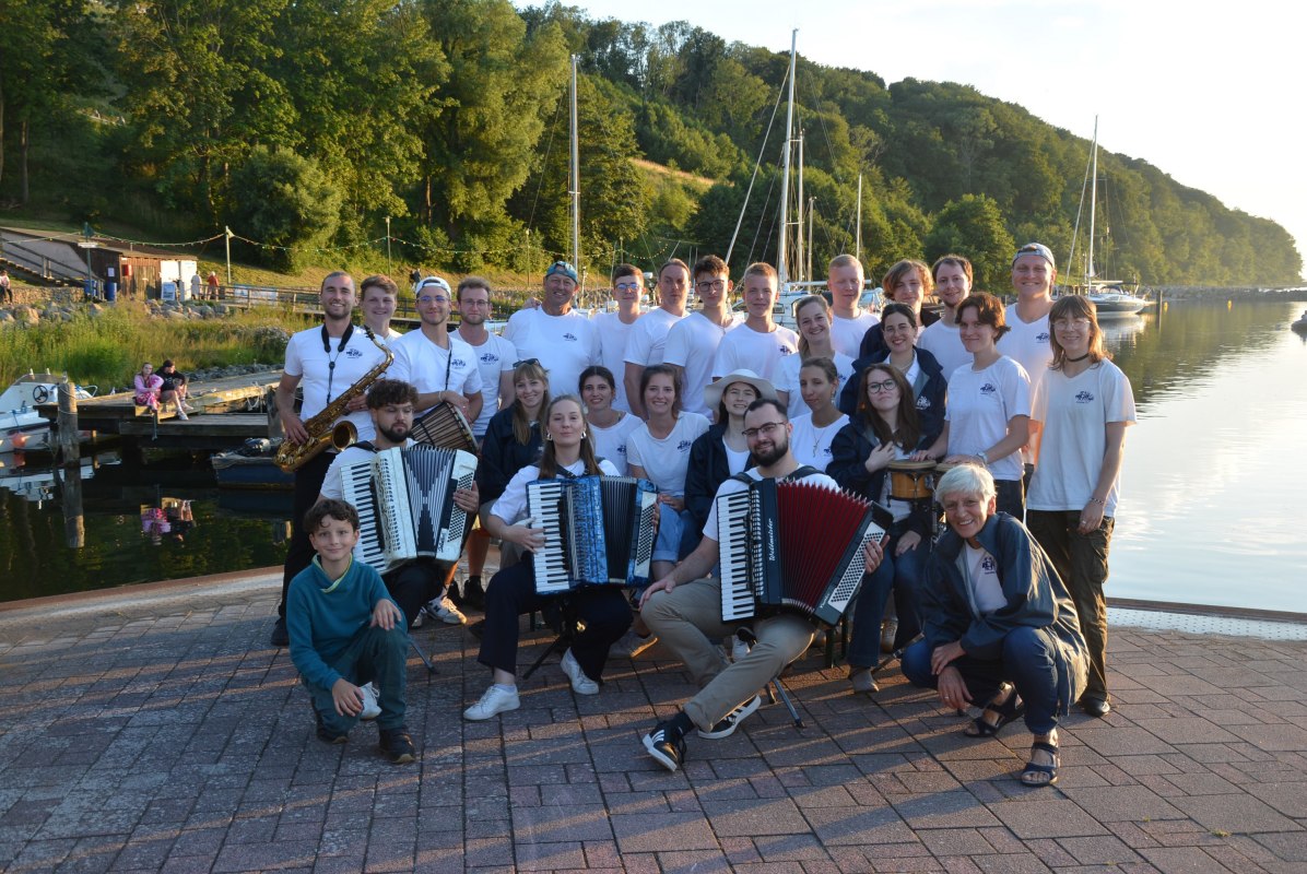 Het jeugdorkest staat in Lohme bij de haven; op de achtergrond is het water te zien. // &copy; TREMOLO nonstop