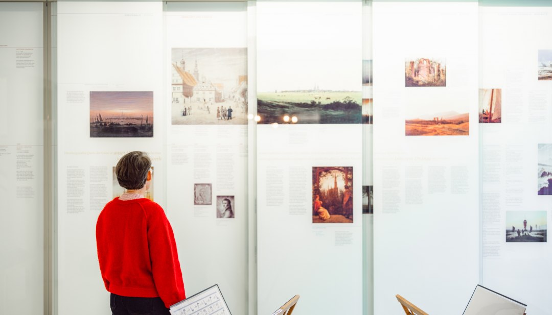 Bezoeker bekijkt reproducties van Caspar David Friedrich in de tentoonstellingsruimte in Greifswald.