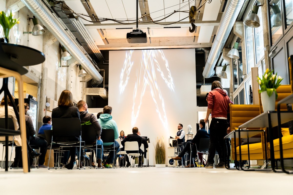 Audience seen from behind in front of a large projection at InnovationPort Wismar // &copy; Ulrike Pawandenat / InnovationPort Wismar