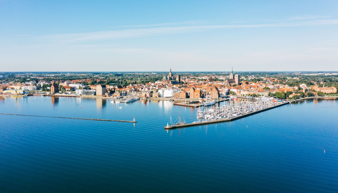 Luchtfoto van de Hanzestad Stralsund met haven, historische oude stad en Baltische Zee onder een blauwe hemel.