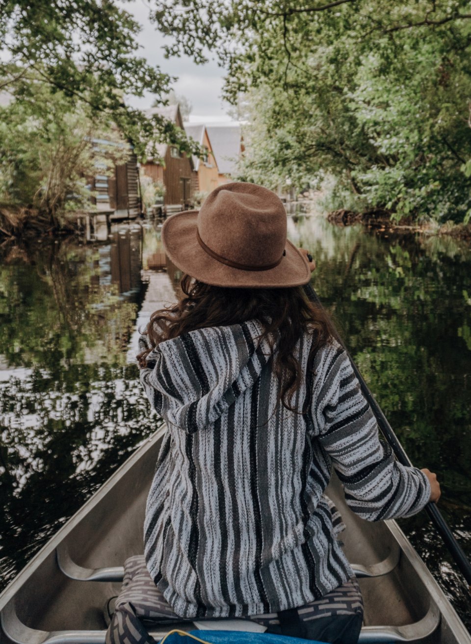 Canoeing along the small canals past boathouses.