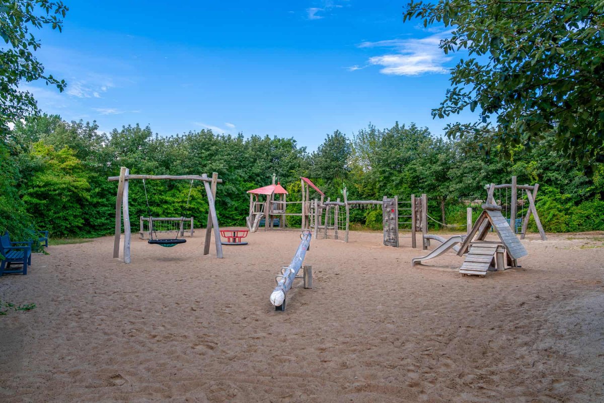 Widok na plac zabaw w centrum miejscowości Ahrenshoop z urządzeniami do wspinania się i huśtawkami. // &copy; Maik Pixelino