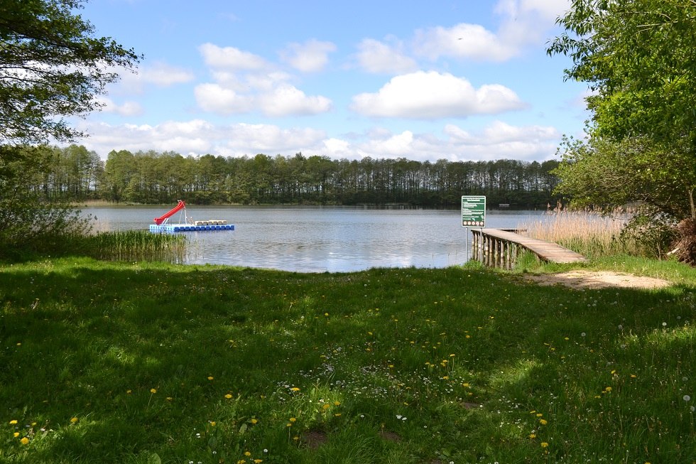 Widok na jezioro z plażą, pomostem i trawnikiem do opalania, © Lutz Werner