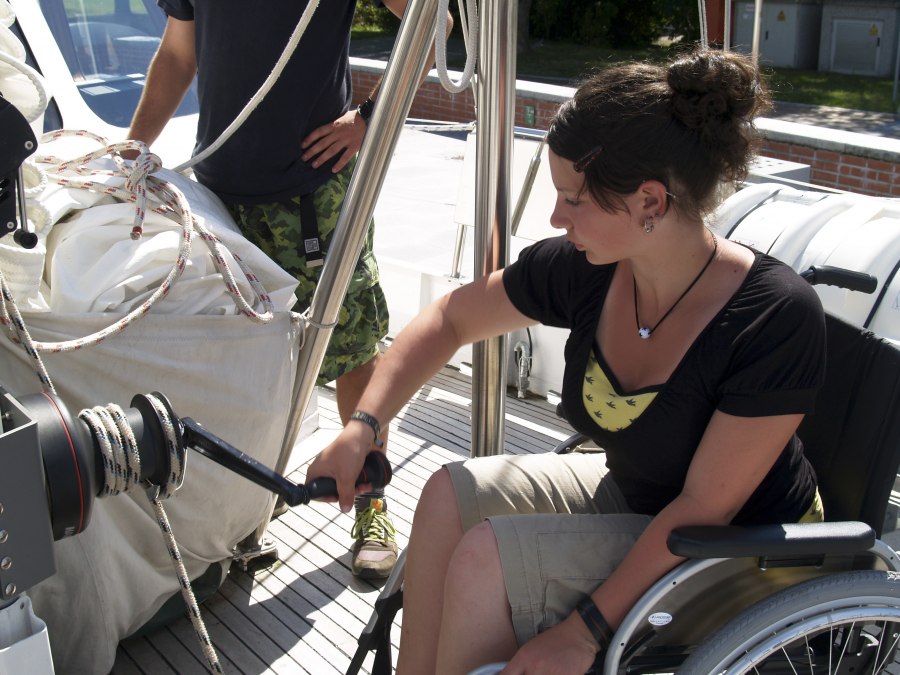 A wheelchair user sits at the crank to "push through" the sail, © Schiffsführung 2007 A wheelchair user sits at the crank to "push through" the sail, © Schiffsführung 2007