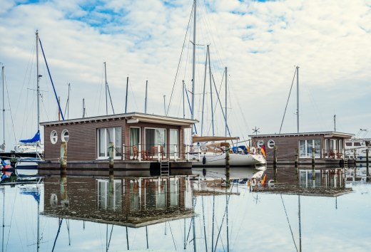 Barki i żaglówki zacumowane w porcie Krummin // Pływające wakacje: apartamenty, zaprojektowane w stylu łodzi mieszkalnych, są mocno zakotwiczone. // © MV-T/Tiemann Barki i żaglówki zacumowane w porcie Krummin