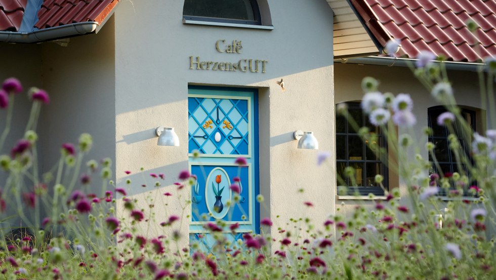 Café HerzensGUT - czarujący mały domek z niebieskimi drzwiami., © Thomas Mandt