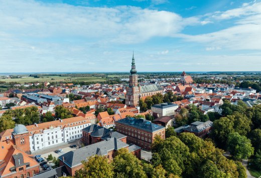 Het silhouet van Greifswald vanuit de lucht met overdag uitzicht op de kerktorens en het oude stadscentrum.