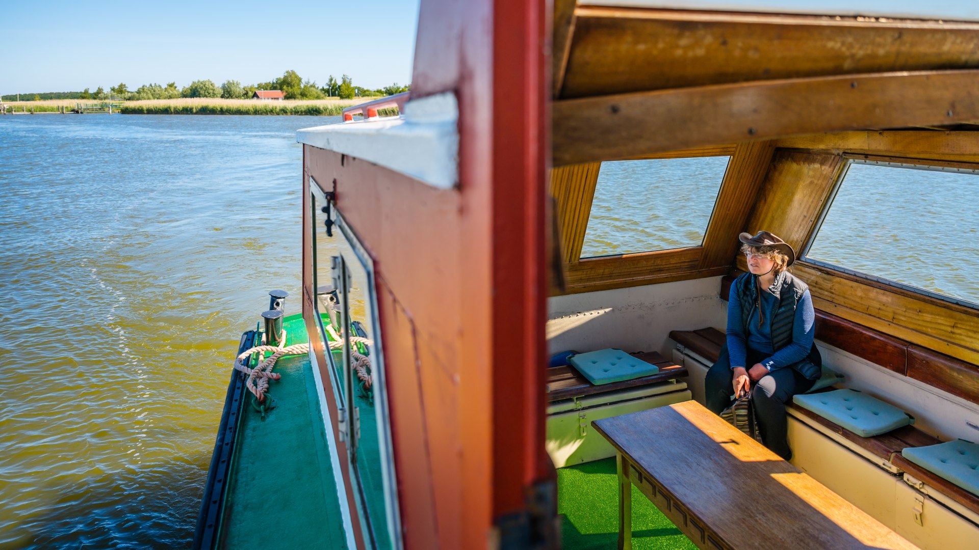 We take the launch over to the Kirr bird sanctuary island. Sylvia Juhnke sits in the boat and looks out into nature.