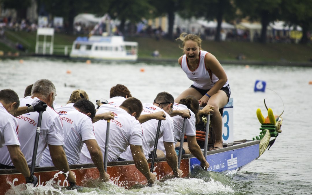 Drakenboot met bemanning op de Pfaffetneich. Een vrouw zit op de boeg, controleert de slag en roept naar het team., © Niclas Rühl/drachenbootfestival.de