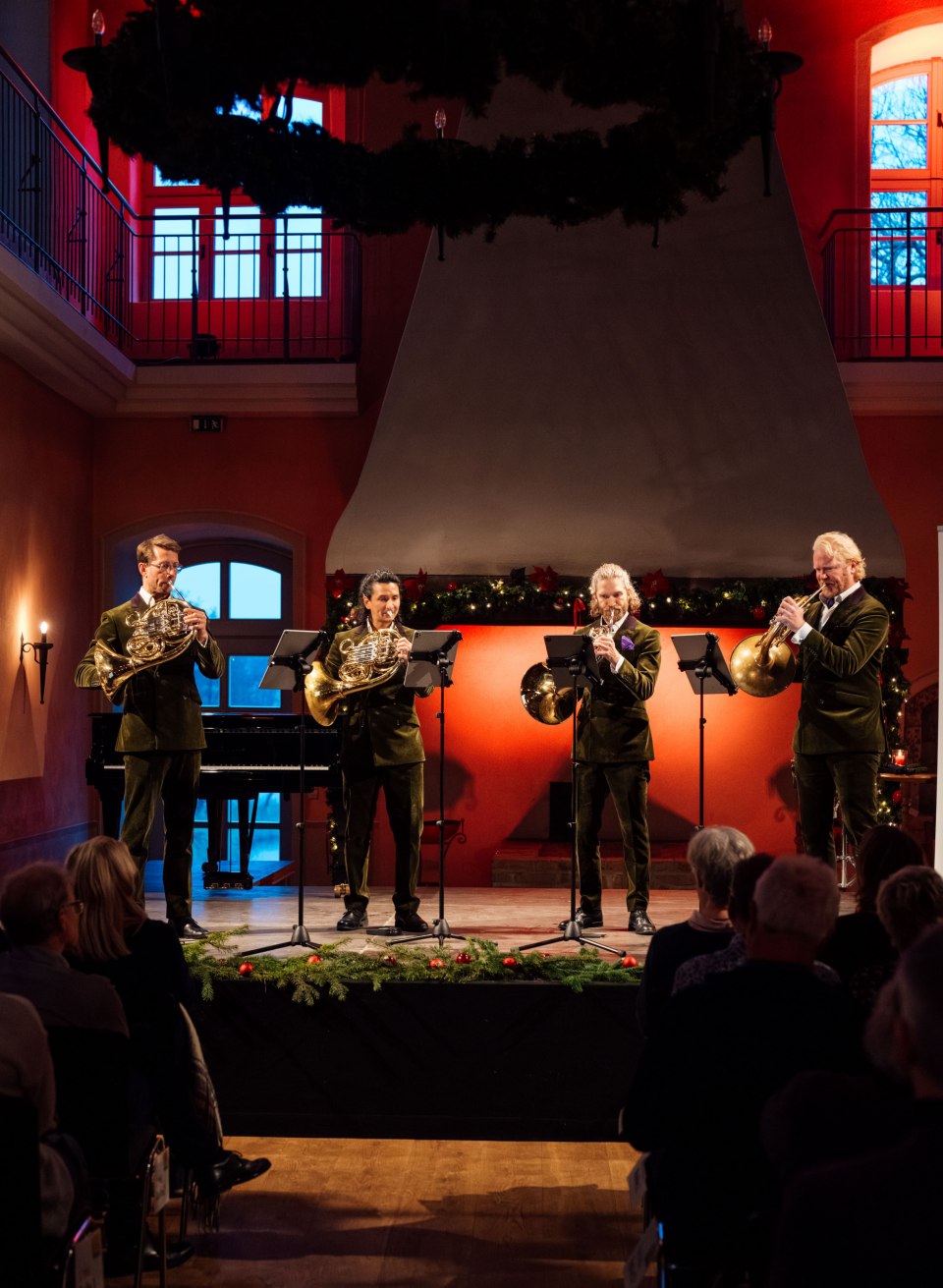 Het Duitse Hornsound Quartet speelt een kerstconcert in het feestelijk versierde kasteel Ulrichshusen voor een enthousiast publiek.