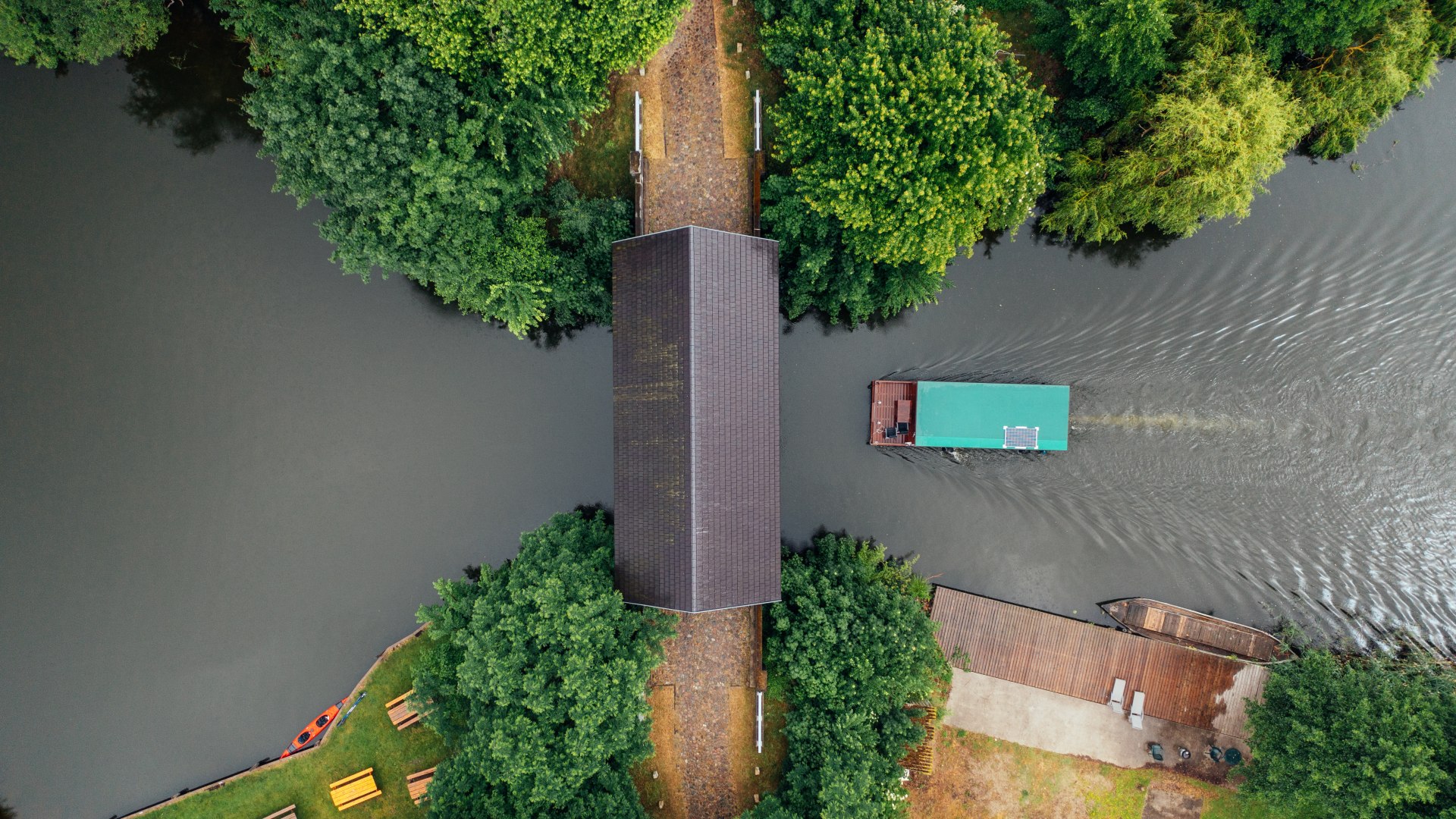 Ahrensberg house bridge - the only preserved house bridge in northern Germany. A picture of the bridge from above and a houseboat passing underneath.