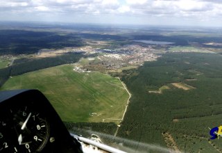 Widok z kokpitu. Po lewej stronie na pierwszym planie znajduje się lotnisko Neustadt. Za nim widać miasto Neustadt-Glewe z jeziorem Neustadt. // © SFC Neustadt-Glewe Widok z kokpitu. Po lewej stronie na pierwszym planie znajduje się lotnisko Neustadt. Za nim widać miasto Neustadt-Glewe z jeziorem Neustadt. // © SFC Neustadt-Glewe