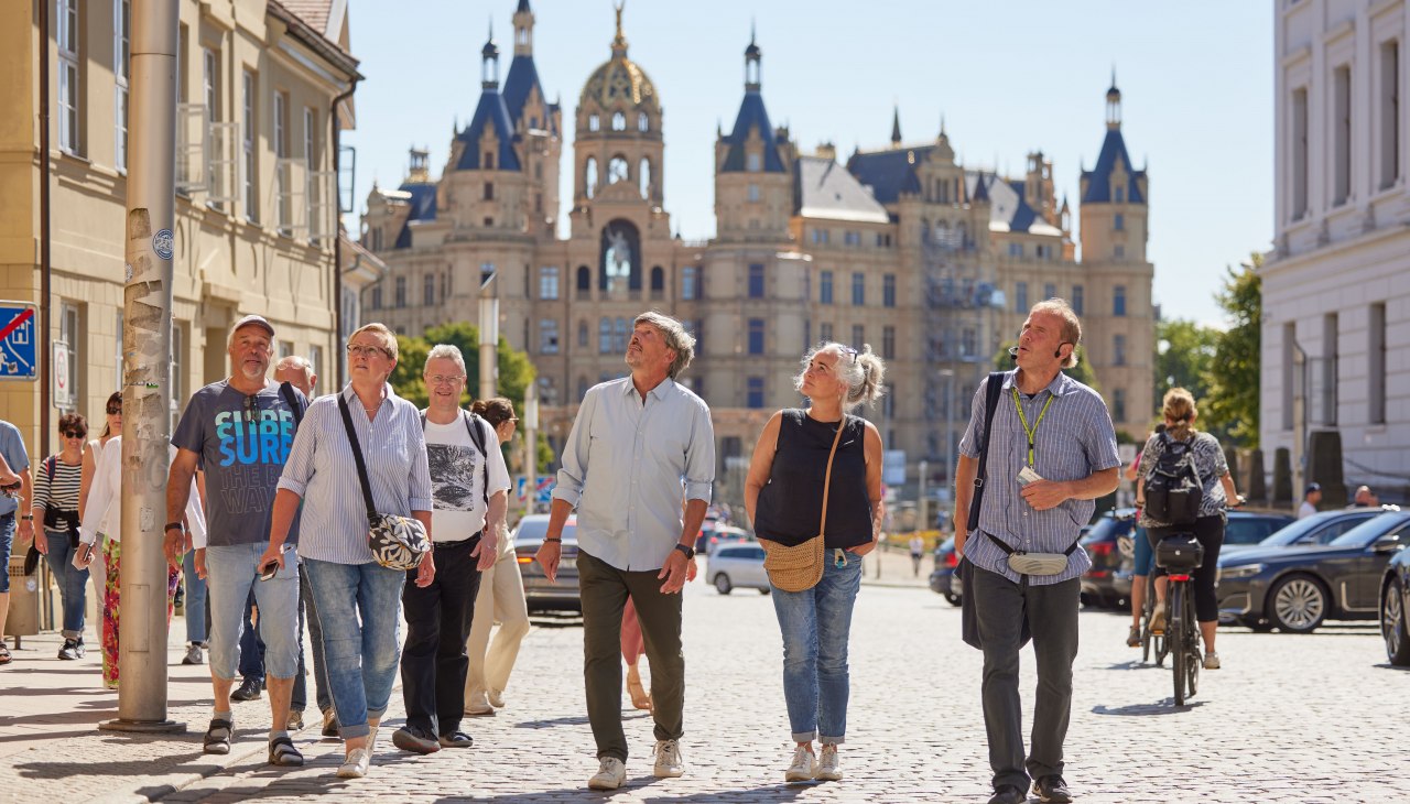 Zwiedzanie miasta z przewodnikiem, w tle zamek Schwerin., © Stadtmarketing Schwerin | Oliver Borchert