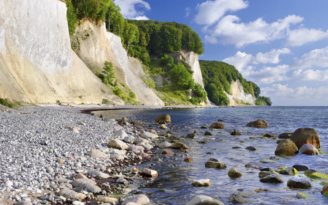 Jasne, białe klify kredowe wznoszą się stromo z Morza Bałtyckiego w Parku Narodowym Jasmund. Okrągłe kamienie otaczają czystą wodę, a gęsty las bukowy wieńczy klify - naturalne dziedzictwo Rugii, które sprawia, że siła żywiołów jest namacalna. // © Francesco Carovillano Jasne, białe klify kredowe wznoszą się stromo z Morza Bałtyckiego w Parku Narodowym Jasmund. Okrągłe kamienie otaczają czystą wodę, a gęsty las bukowy wieńczy klify - naturalne dziedzictwo Rugii, które sprawia, że siła żywiołów jest namacalna. // © Francesco Carovillano