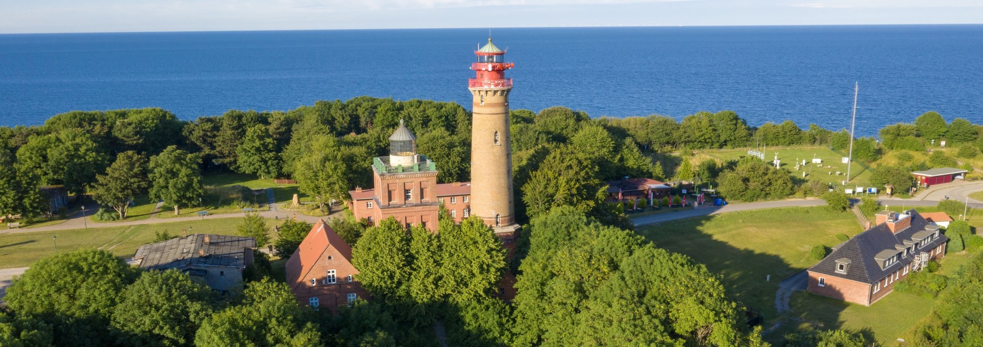 Aerial view of the lighthouses of Cape Arkona on the island of Rügen, surrounded by green nature and the blue Baltic Sea.