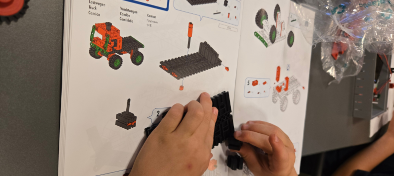 Two children's hands build a Lego car with the help of instructions // © Stadtbibliothek Stralsund Two children's hands build a Lego car with the help of instructions // © Stadtbibliothek Stralsund