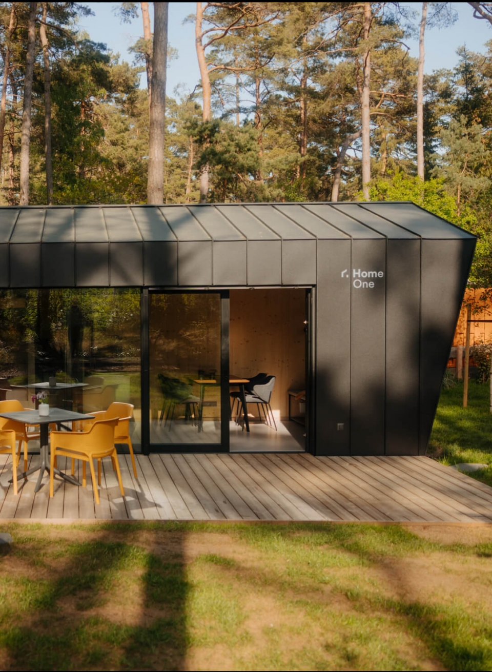 Natuur ontmoet design - stijlvol tiny house midden in het bos voor een ontspannen vakantie in comfort en rust., © Cabin28 Modern tiny house met donkere gevel, groot houten terras en buitenzitje, idyllisch gelegen in het bos.