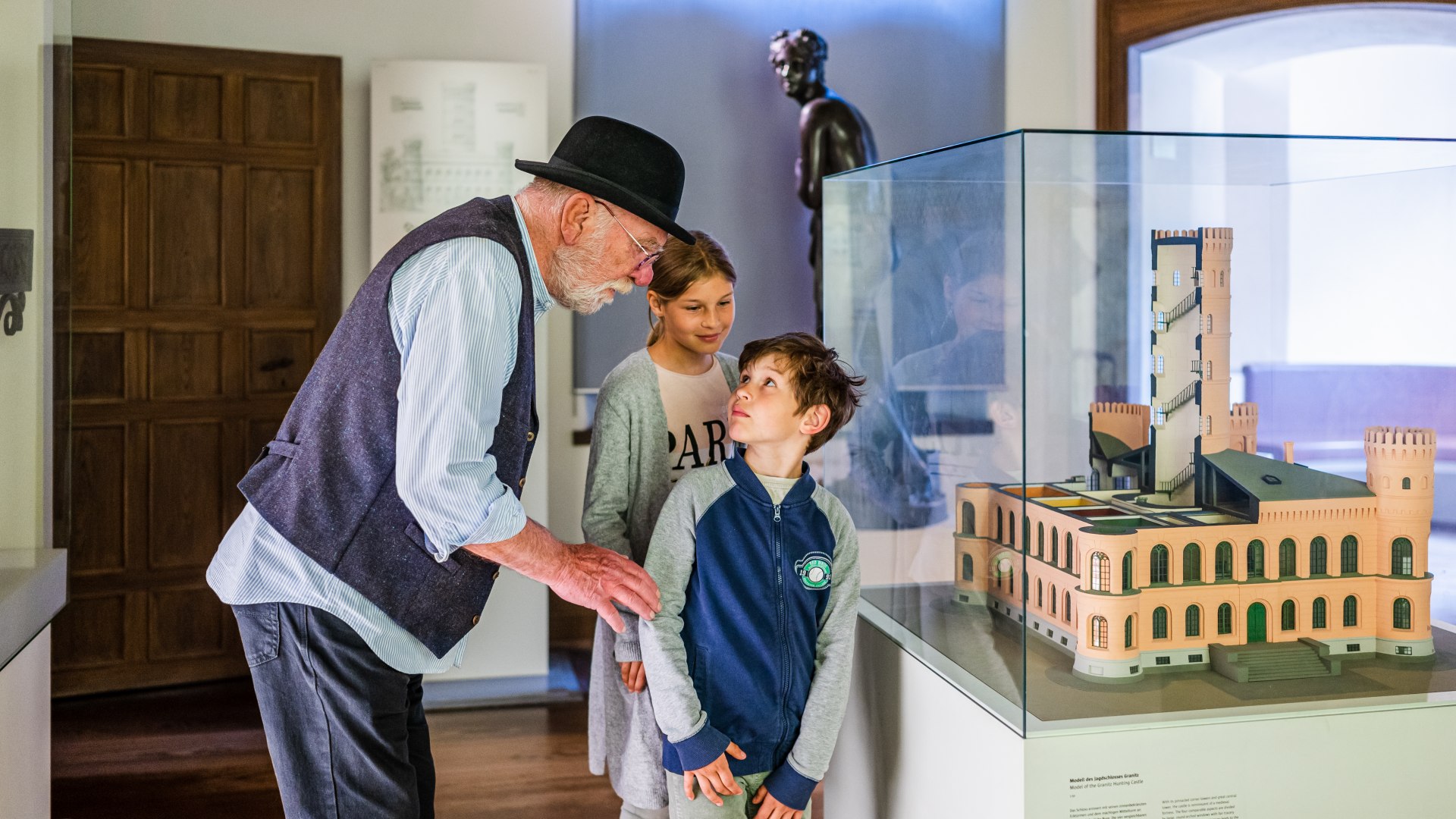 Children stand with the tour guide in front of the model of Granitz Castle // First a look at the big picture: a model of the fairytale Granitz Castle. // © MV-T/Tiemann Children stand with the tour guide in front of the model of Granitz Castle
