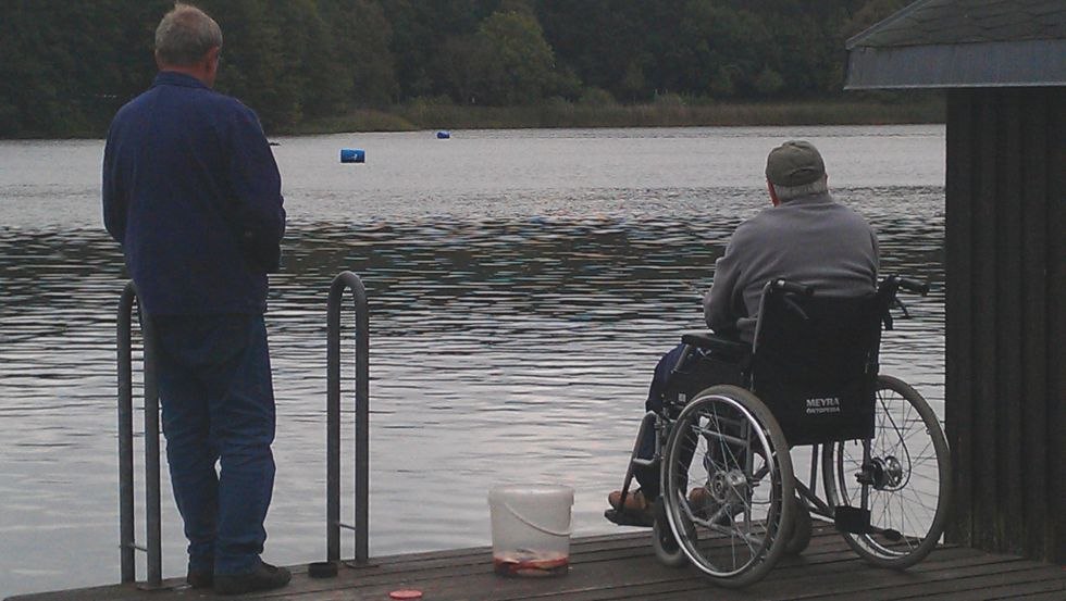 Holidaymaker in wheelchair gets assistance with fishing // © Birkenzweig e. V. Holidaymaker in wheelchair gets assistance with fishing // © Birkenzweig e. V.