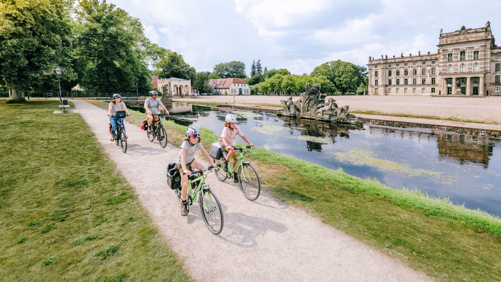 Een familie fietst voorbij voor het paleis van Ludwigslust.