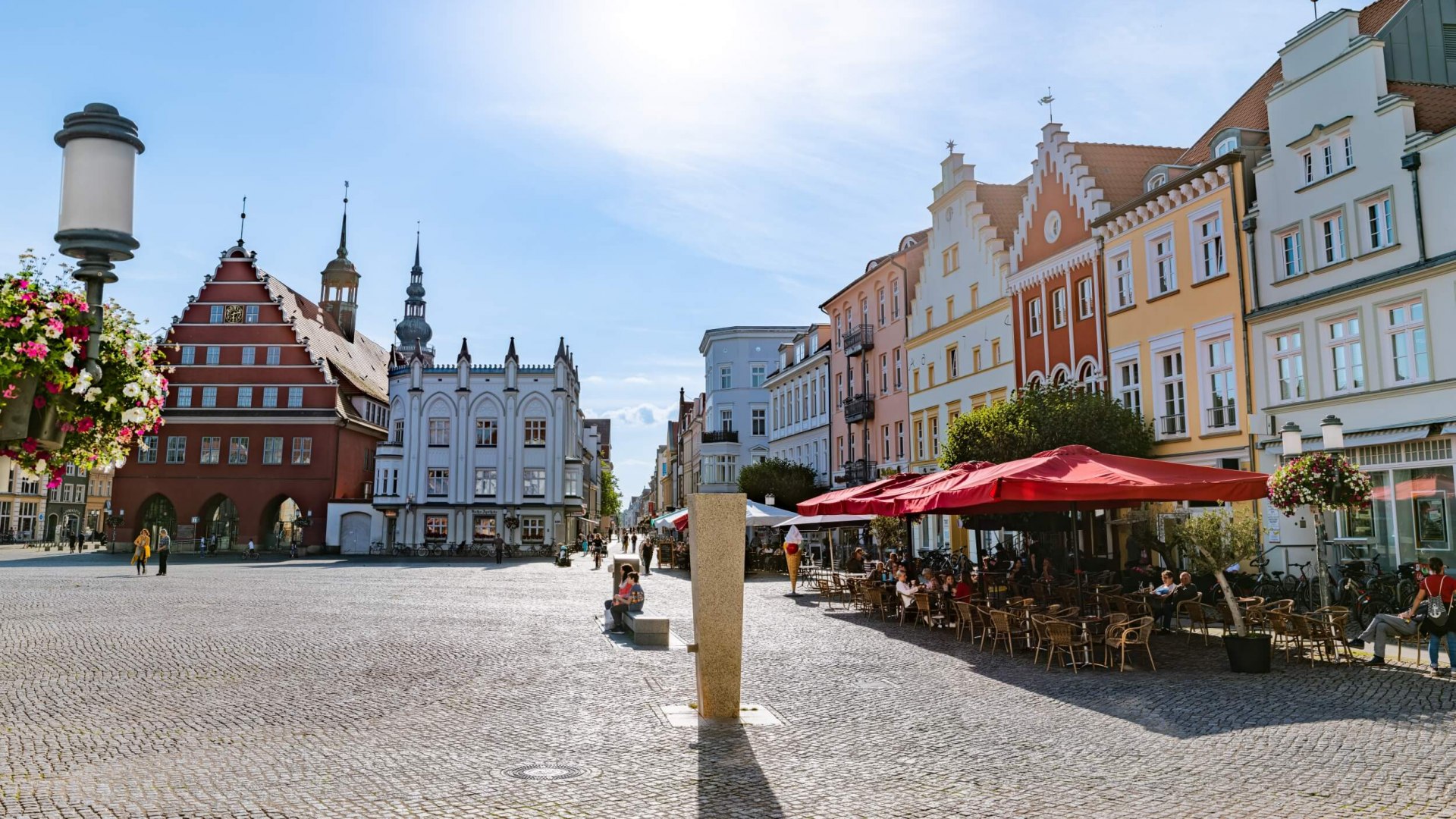 Het marktplein van Greifswald met Hanzegebouwen, cafés en het toeristeninformatiecentrum.