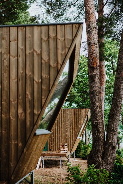 Minimalistisch wonen, maximale ontspanning - stijlvolle houten tiny houses bieden natuurlijk comfort voor een speciale time-out., © Ahoi Camp Canow Architectonisch moderne huisjes met houten gevels en grote panoramische ramen, genesteld in een bos bij een meer.