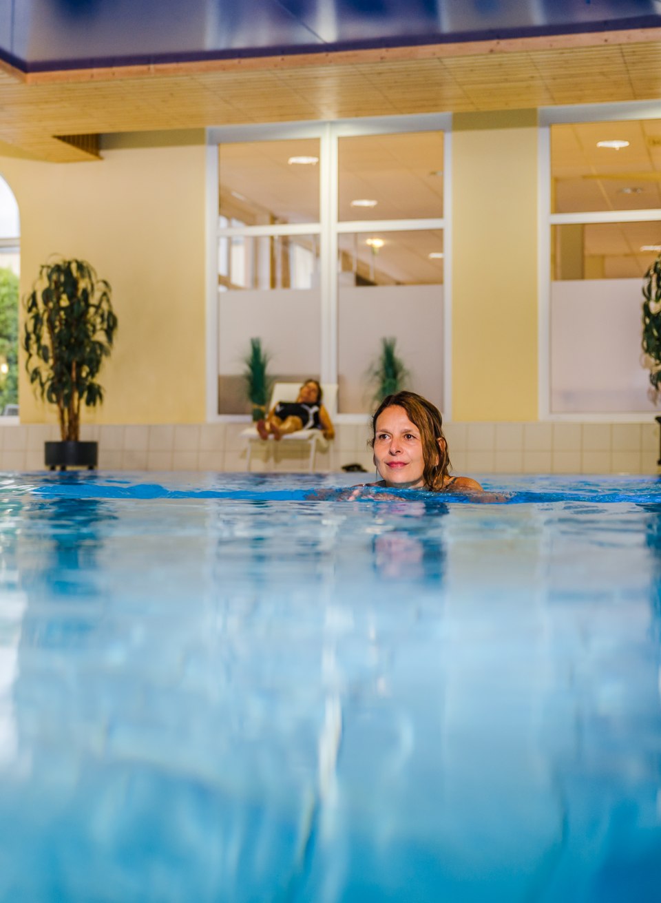 Kobieta pływa we własnym basenie Medical Wellness Centre. // Hotelowy basen zaprasza do pływania w każdą pogodę. // © MV-T/Tiemann Kobieta pływa we własnym basenie Medical Wellness Centre.