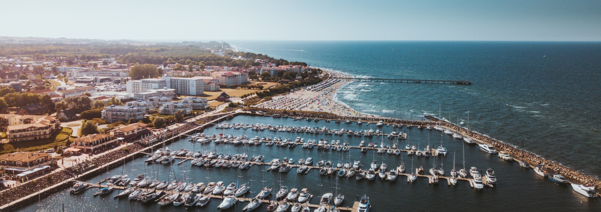 Aerial view of Kühlungsborn marina with numerous boats and the long sandy beach on the Baltic Sea. // Maritime flair and Baltic Sea enjoyment - Kühlungsborn's marina with its lively harbor life and the fine sandy beach attract visitors to spend relaxing days on the Baltic Sea coast of Mecklenburg. // © MV-T/Friedrich Aerial view of Kühlungsborn marina with numerous boats and the long sandy beach on the Baltic Sea.