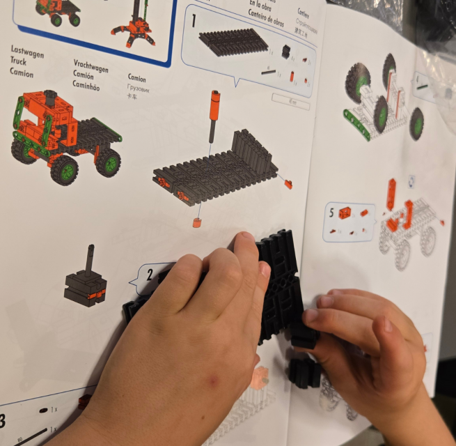 Two children's hands build a Lego car with the help of instructions // &copy; Stadtbibliothek Stralsund